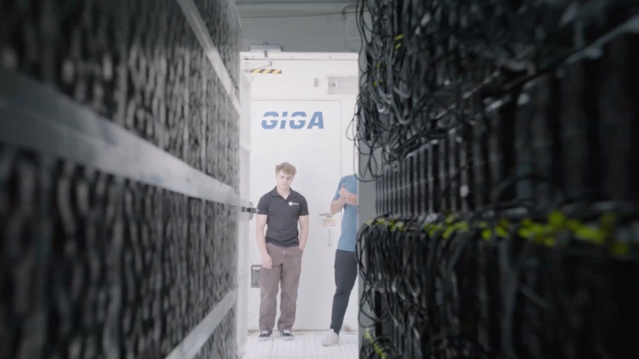 Interior view of a high-density Bitcoin mining container showing technician monitoring rows of ASIC miners with organized cabling and industrial airflow management.